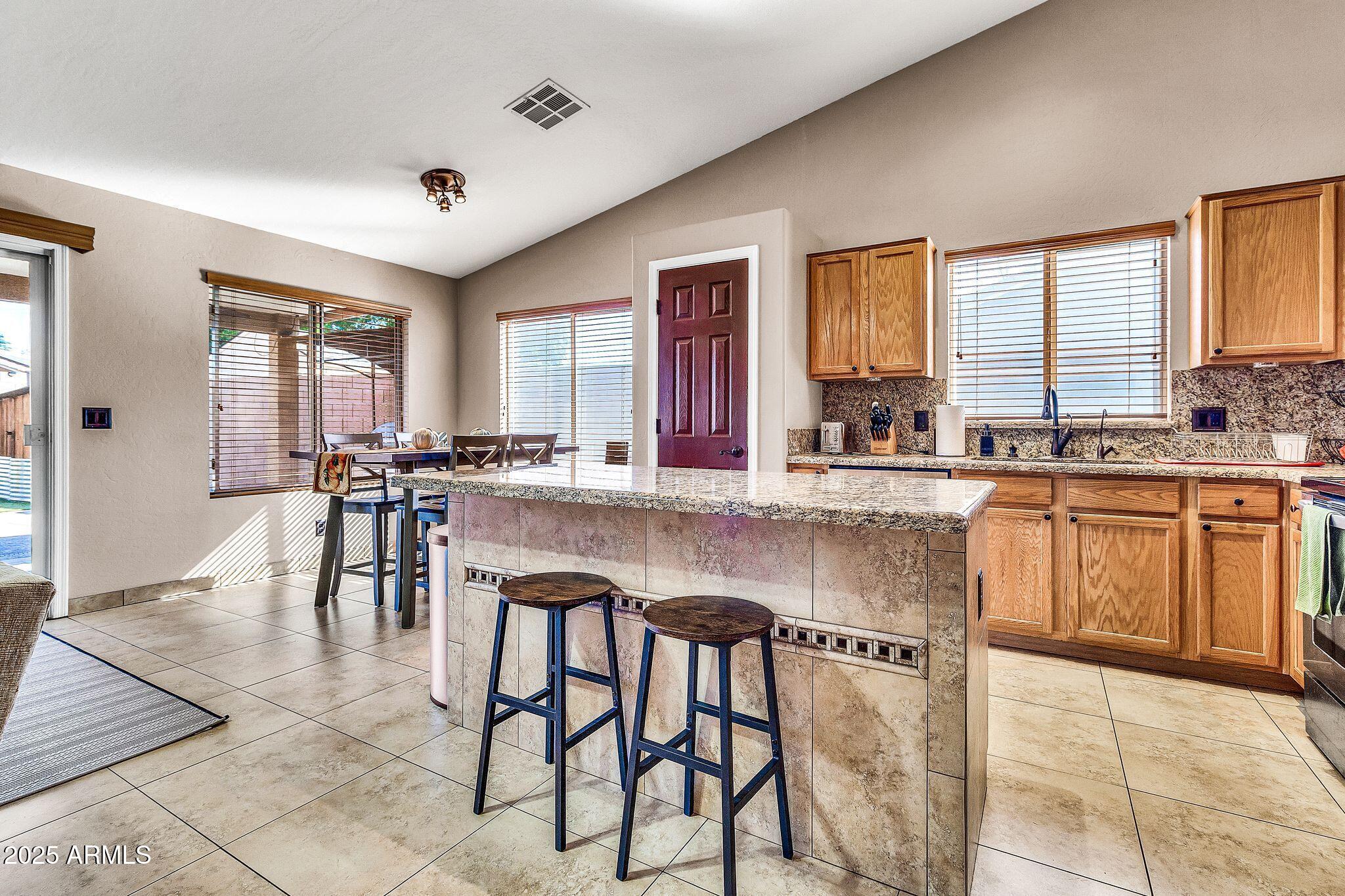 3048 East Erie Street Gilbert, AZ 85295 - Photo 10 of 44 a kitchen with stainless steel appliances granite countertop table chairs sink and cabinets