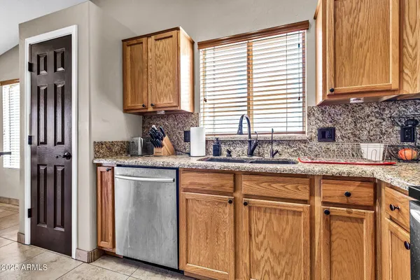 a kitchen with stainless steel appliances granite countertop white cabinets and a sink