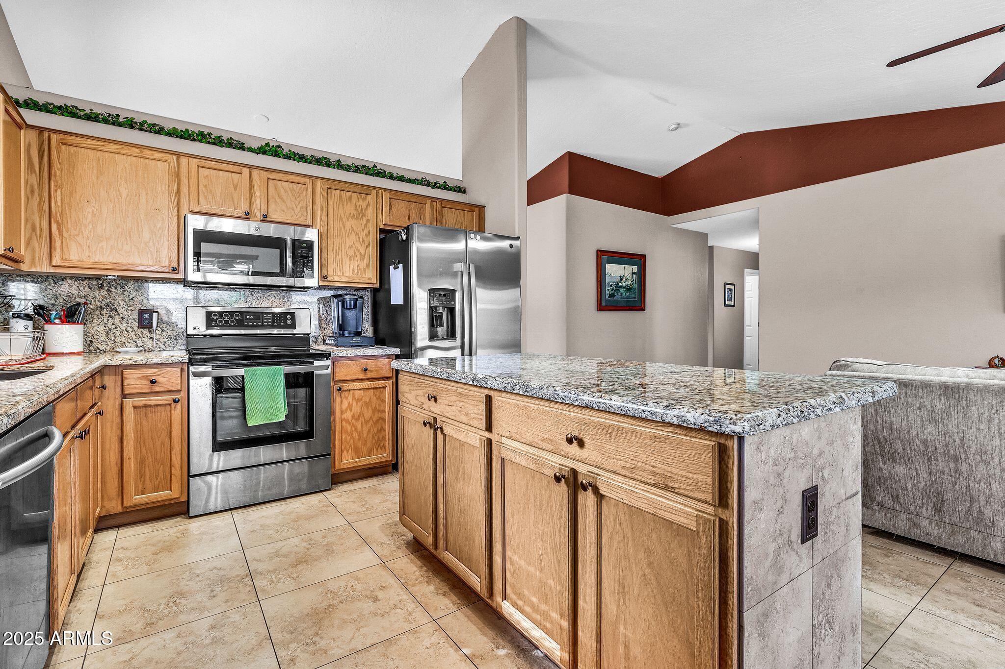 3048 East Erie Street Gilbert, AZ 85295 - Photo 14 of 44 a kitchen with stainless steel appliances granite countertop a stove top oven a sink and a microwave