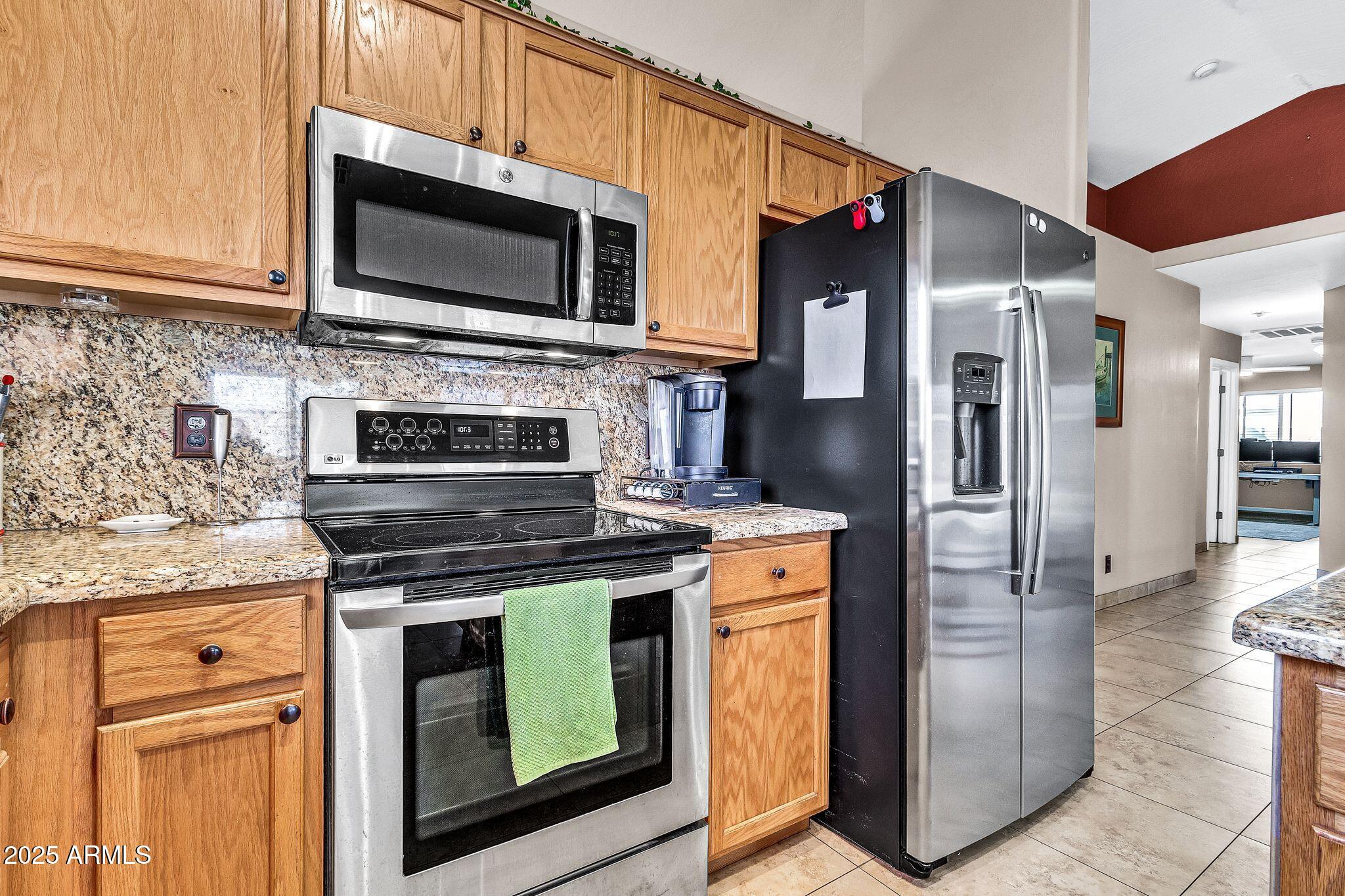 3048 East Erie Street Gilbert, AZ 85295 - Photo 15 of 44 a kitchen with stainless steel appliances granite countertop a stove microwave and refrigerator