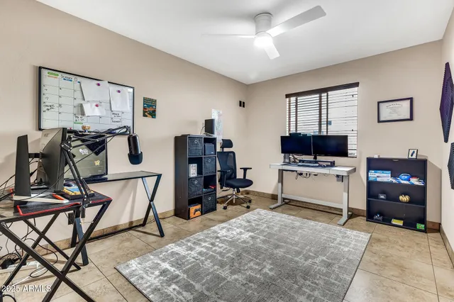 a room with furniture a flat screen tv and a ceiling fan