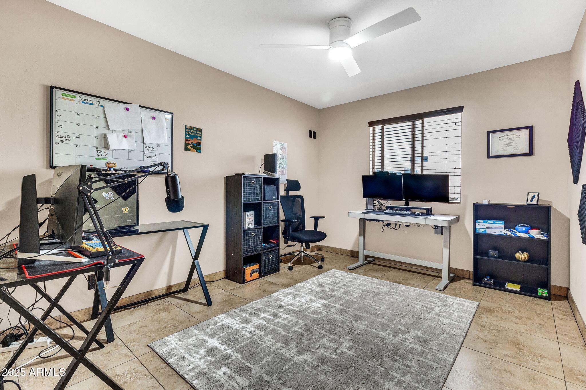 3048 East Erie Street Gilbert, AZ 85295 - Photo 24 of 44 a room with furniture a flat screen tv and a ceiling fan