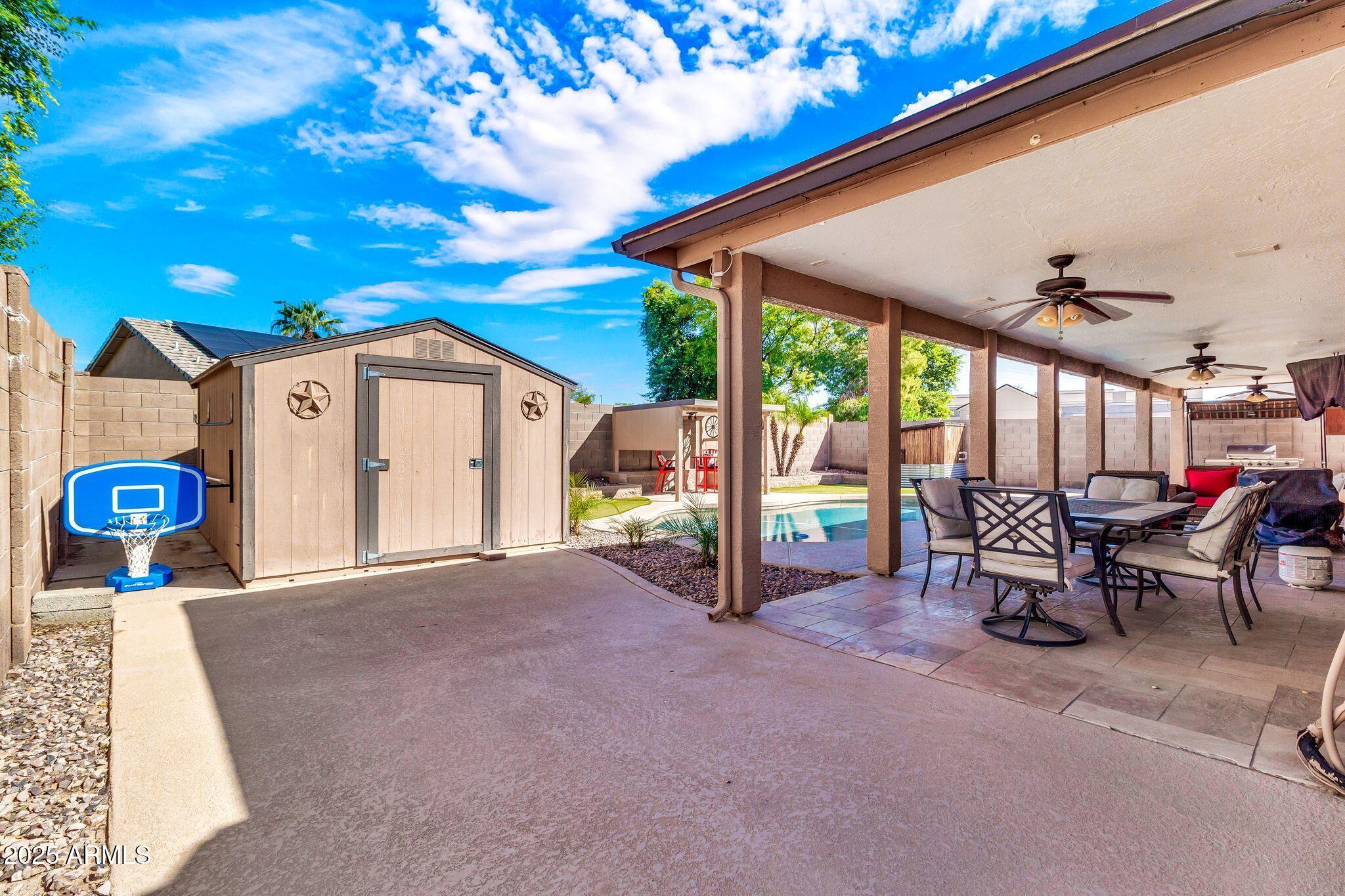 3048 East Erie Street Gilbert, AZ 85295 - Photo 34 of 44 a view of a patio with a table and chairs under an umbrella