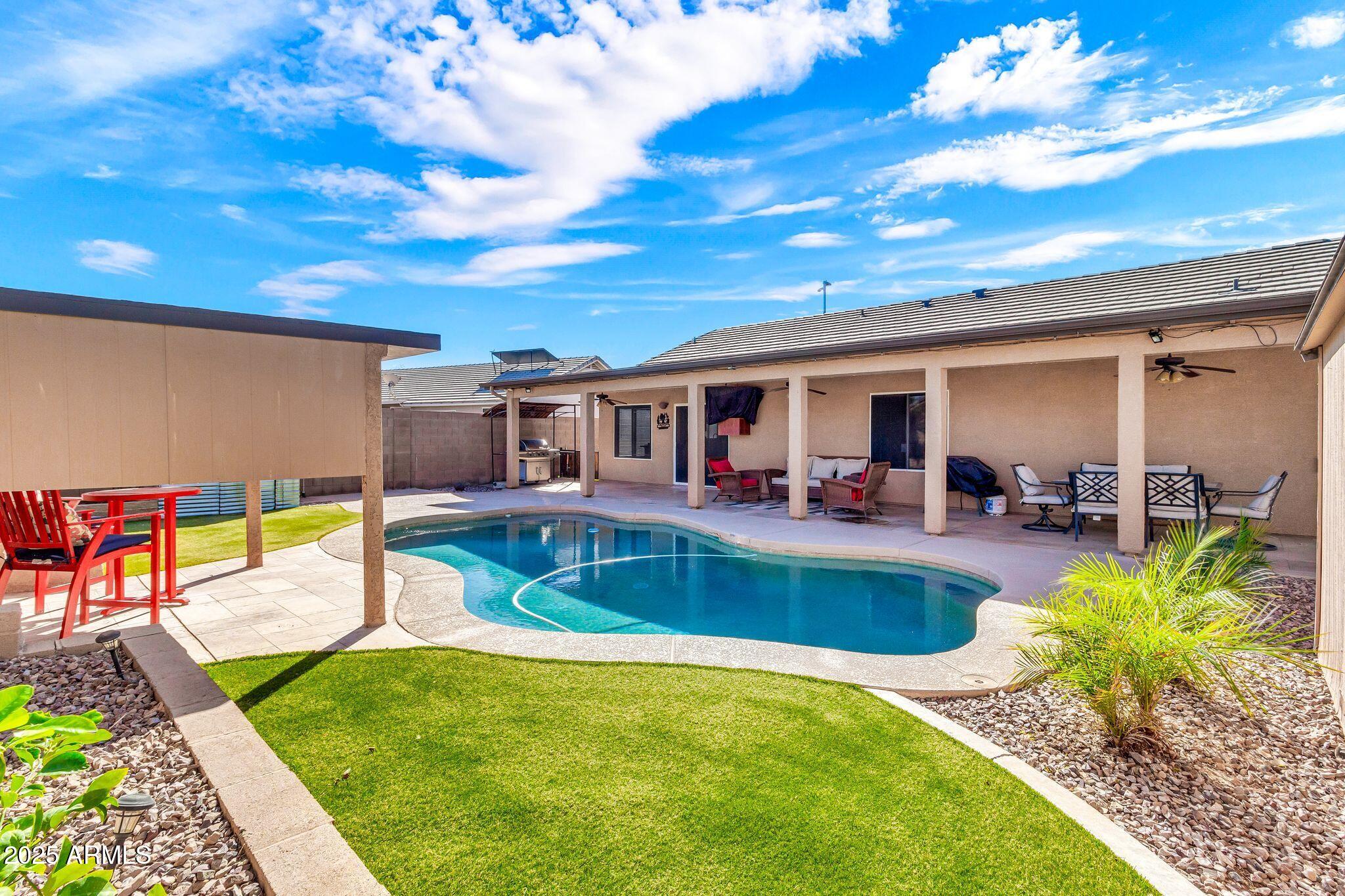 3048 East Erie Street Gilbert, AZ 85295 - Photo 36 of 44 a view of a swimming pool with a patio and a yard