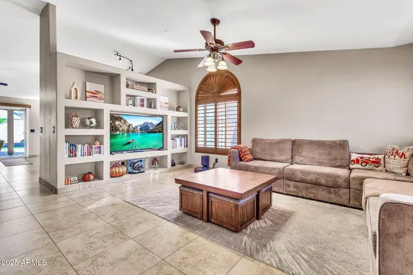 a living room with furniture a chandelier and a flat screen tv