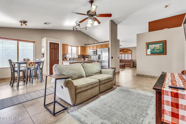 a living room with furniture a chandelier and a dining table