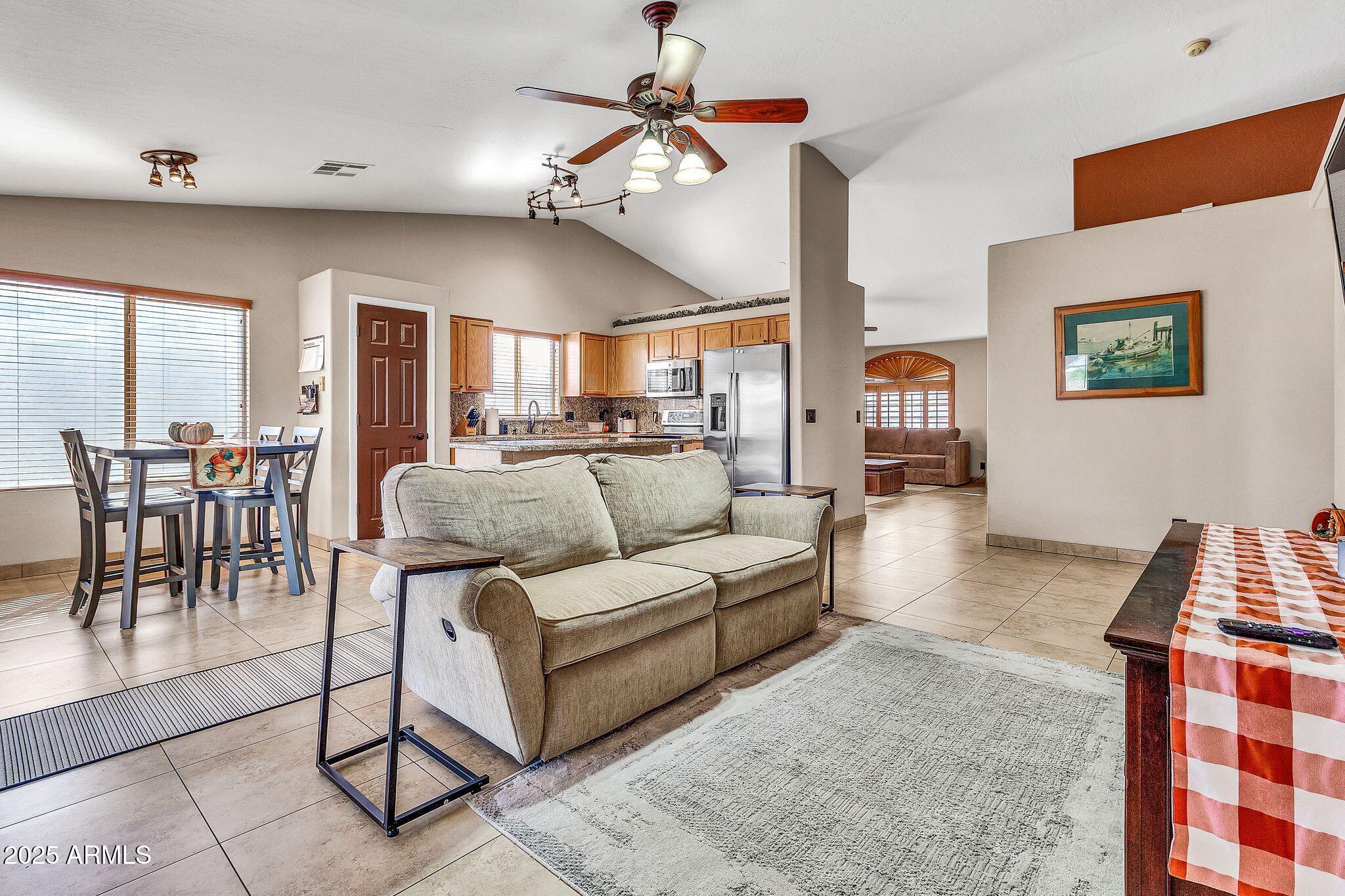 3048 East Erie Street Gilbert, AZ 85295 - Photo 9 of 44 a living room with furniture a chandelier and a dining table