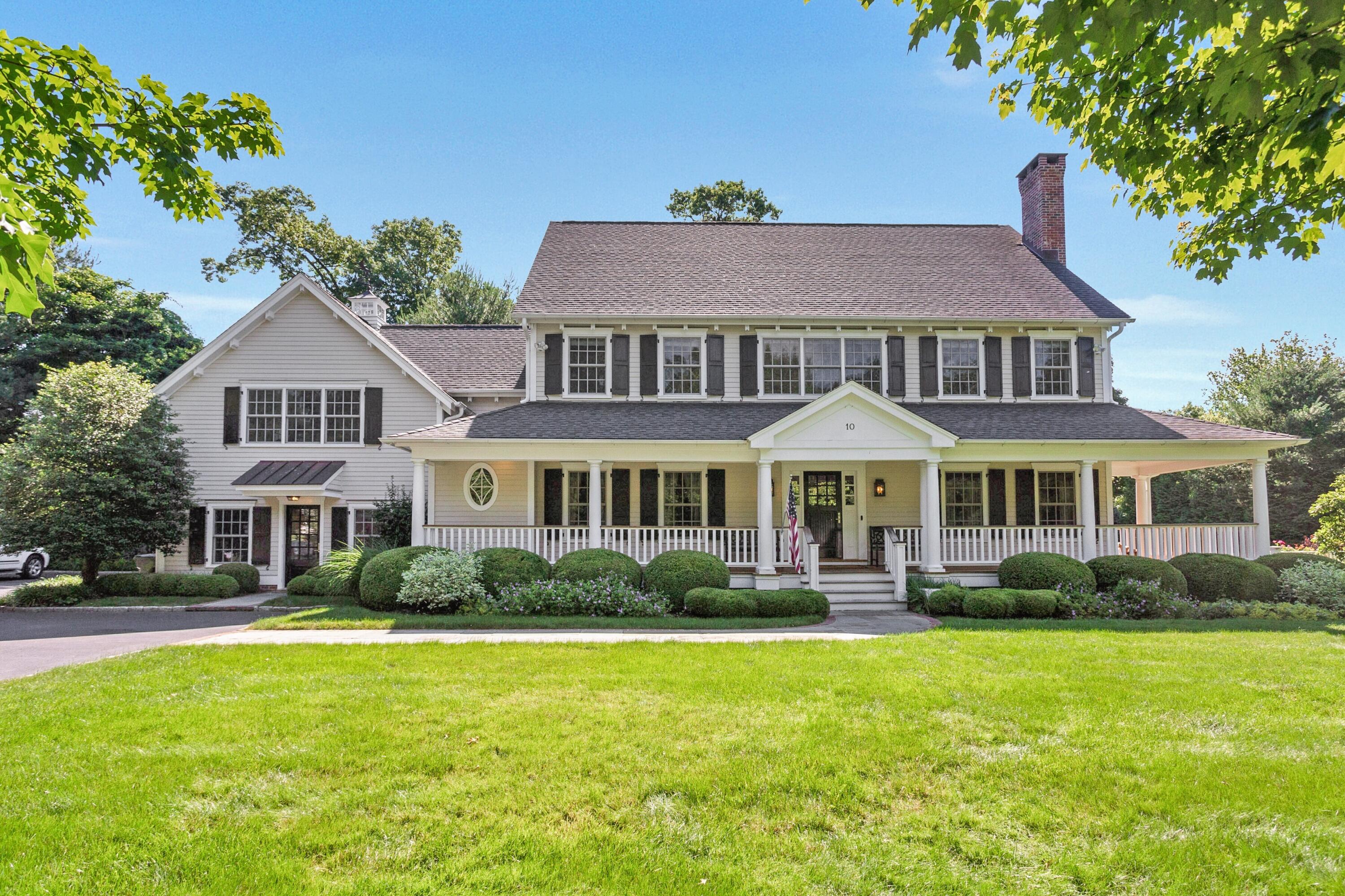a front view of a house with a yard and potted plants
