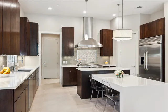 a kitchen with stainless steel appliances kitchen island granite countertop a sink stove and refrigerator