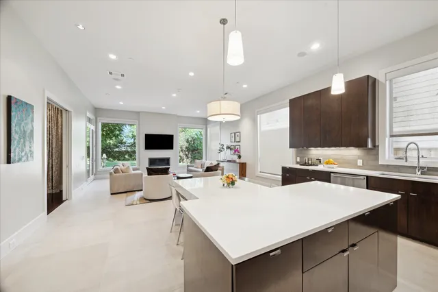a large kitchen with sink a counter top space and living room view