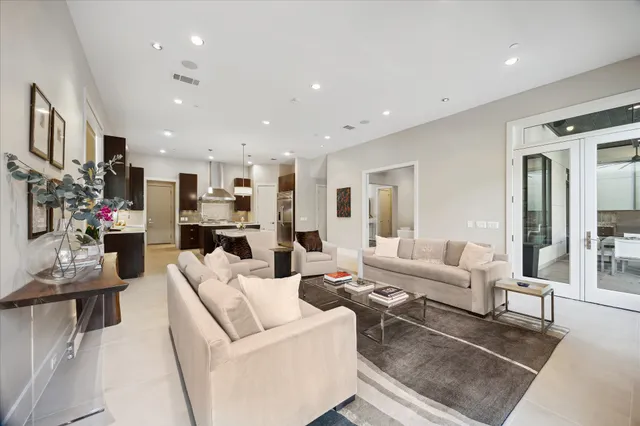 a living room with furniture and a dining table with kitchen view