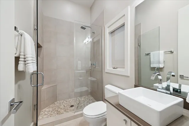 a bathroom with a sink a toilet and shower