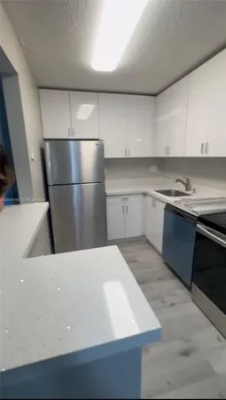 a kitchen with a sink dishwasher and a refrigerator