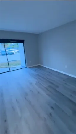 a view of a hallway with wooden floor and entryway