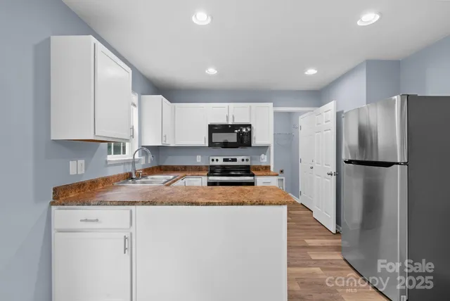 a kitchen with granite countertop a refrigerator a sink a stove a microwave and island