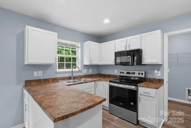 a kitchen with stainless steel appliances granite countertop a sink stove and microwave
