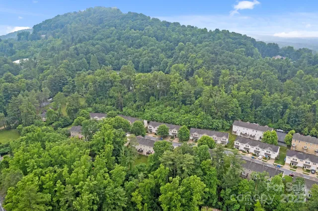 an aerial view of a city with lots of residential buildings and mountain view in back
