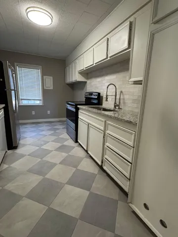 a kitchen with stainless steel appliances granite countertop a sink and cabinets
