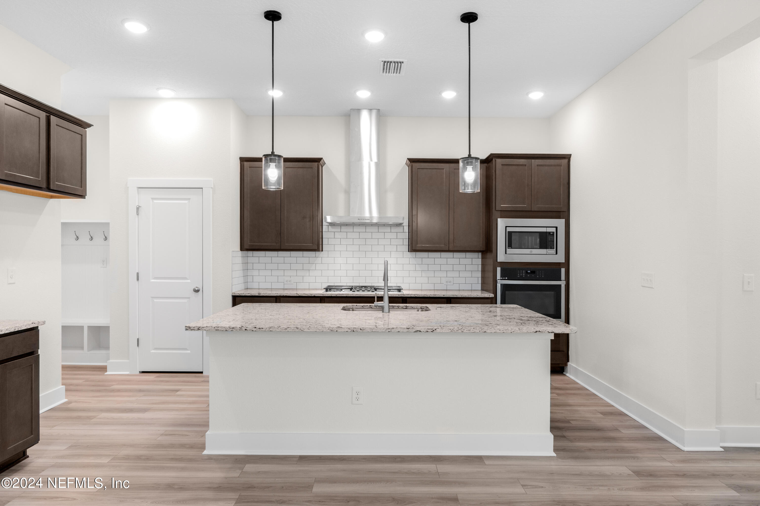 9973 Element Road Jacksonville, FL 32256 - Photo 3 of 18 a large kitchen with stainless steel appliances granite countertop a sink a microwave a refrigerator and white cabinets