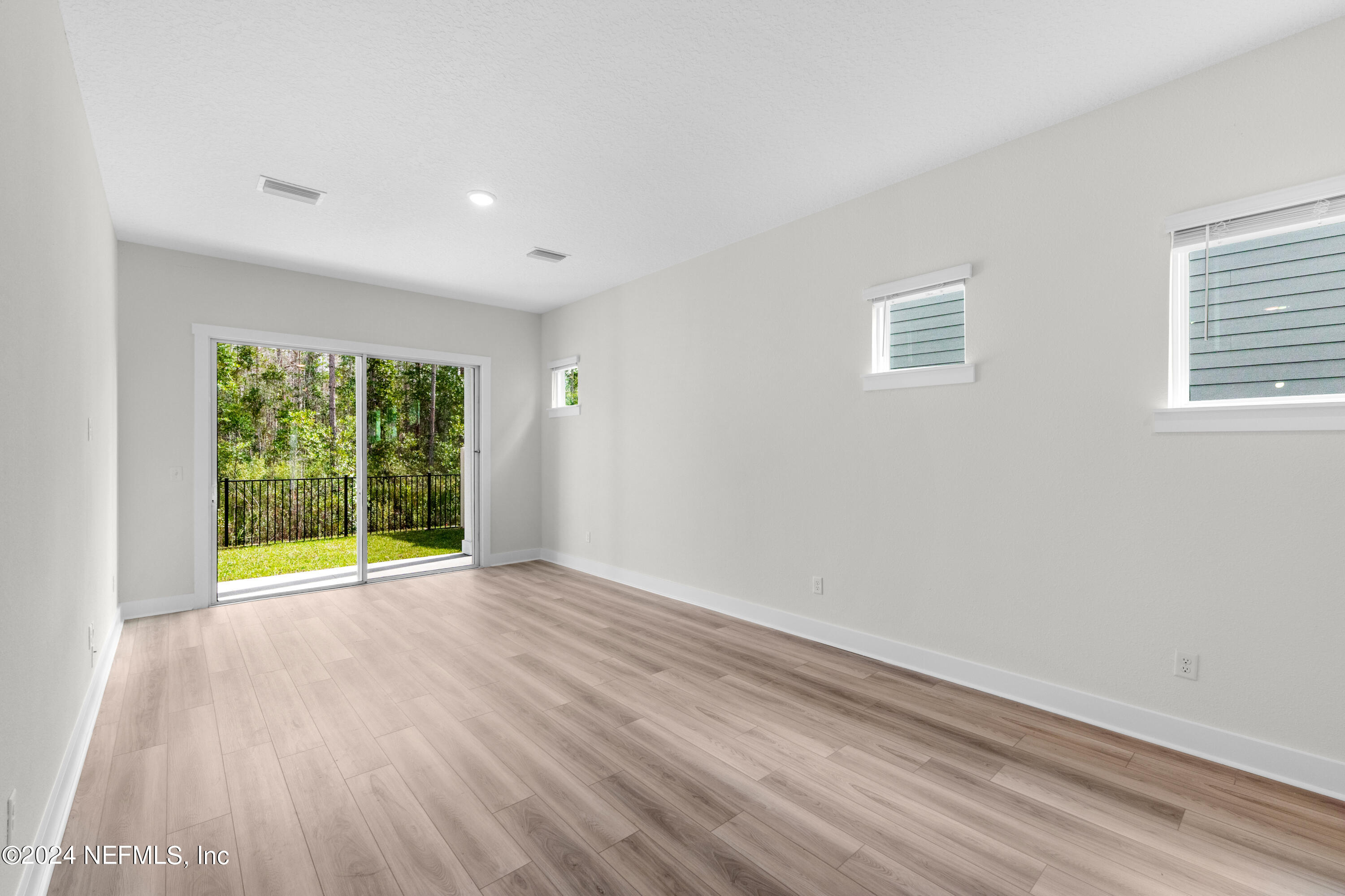 9973 Element Road Jacksonville, FL 32256 - Photo 8 of 18 a view of an empty room with wooden floor and a window