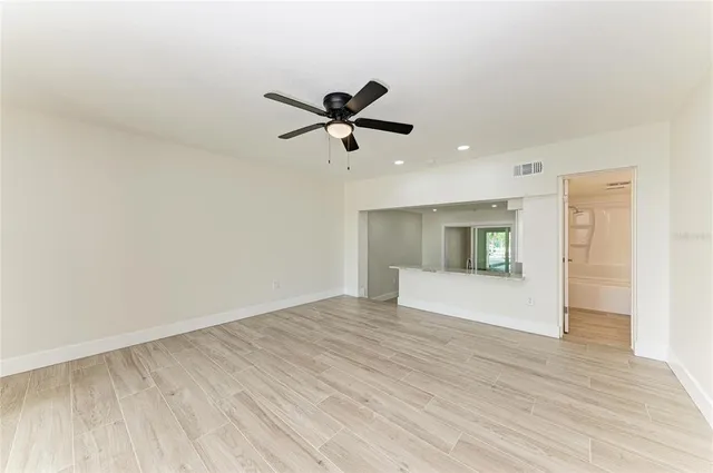 a kitchen with white cabinets and wooden floor