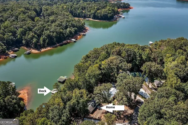 an aerial view of a house with a yard and lake view