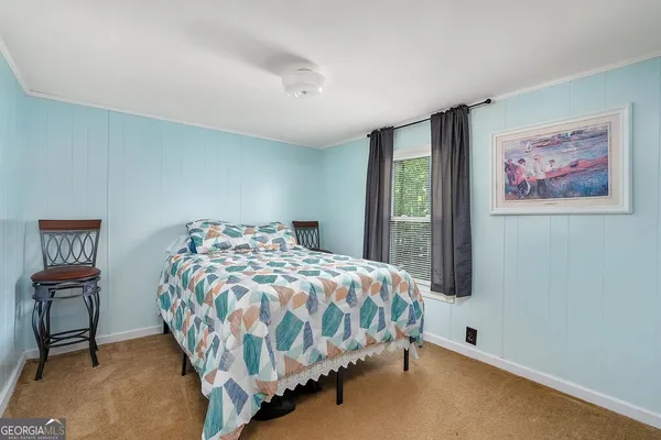 a bedroom with a bed and a painting on the wall