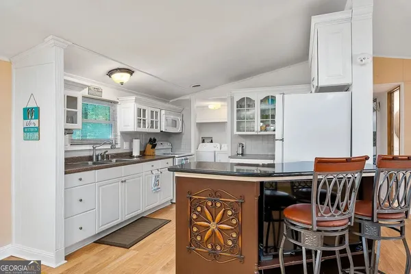 a kitchen with a sink and chairs