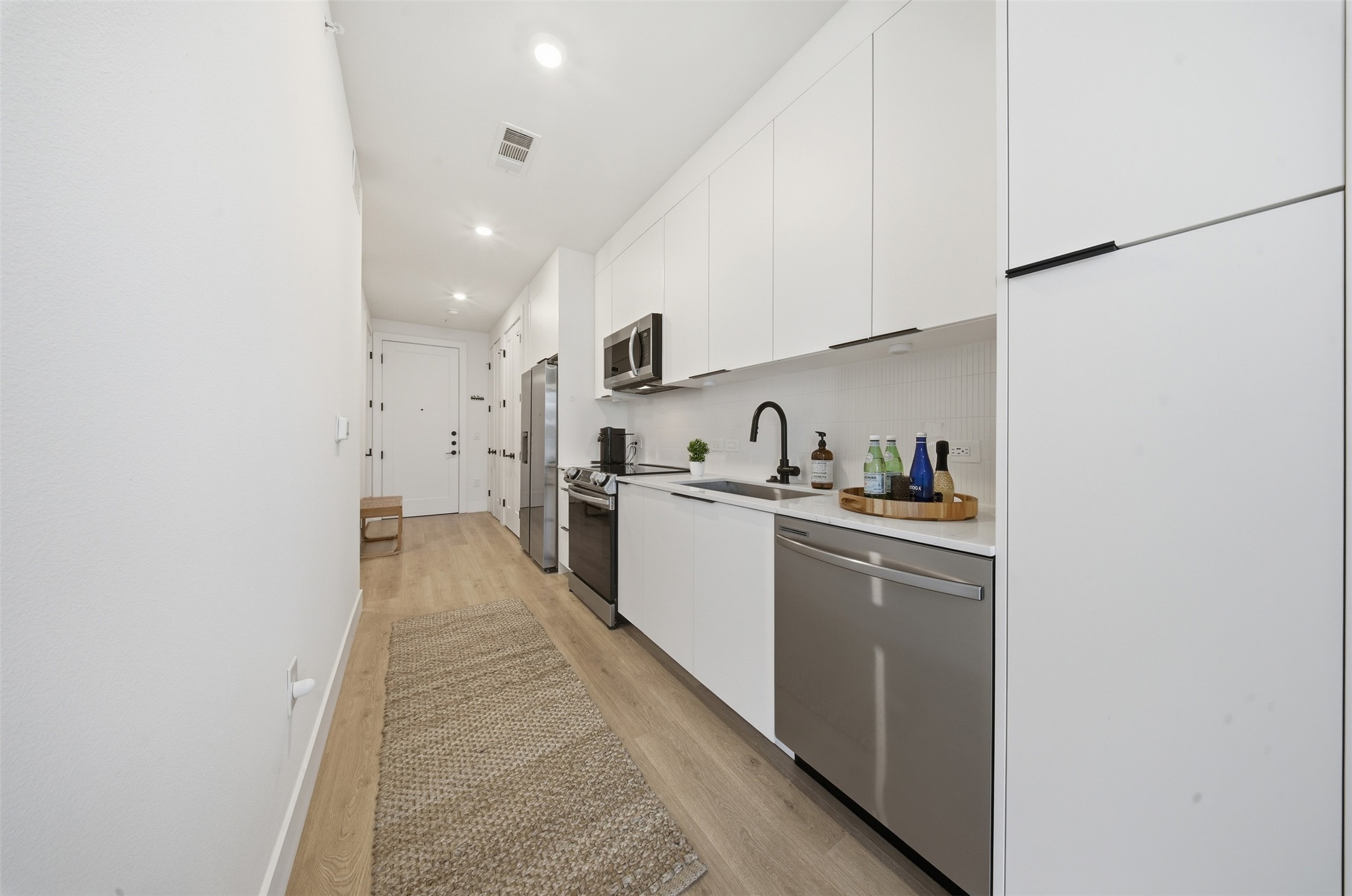 1701 Simond Avenue, Unit 615 Austin, TX 78723 - Photo 7 of 25 a kitchen with cabinets and white appliances