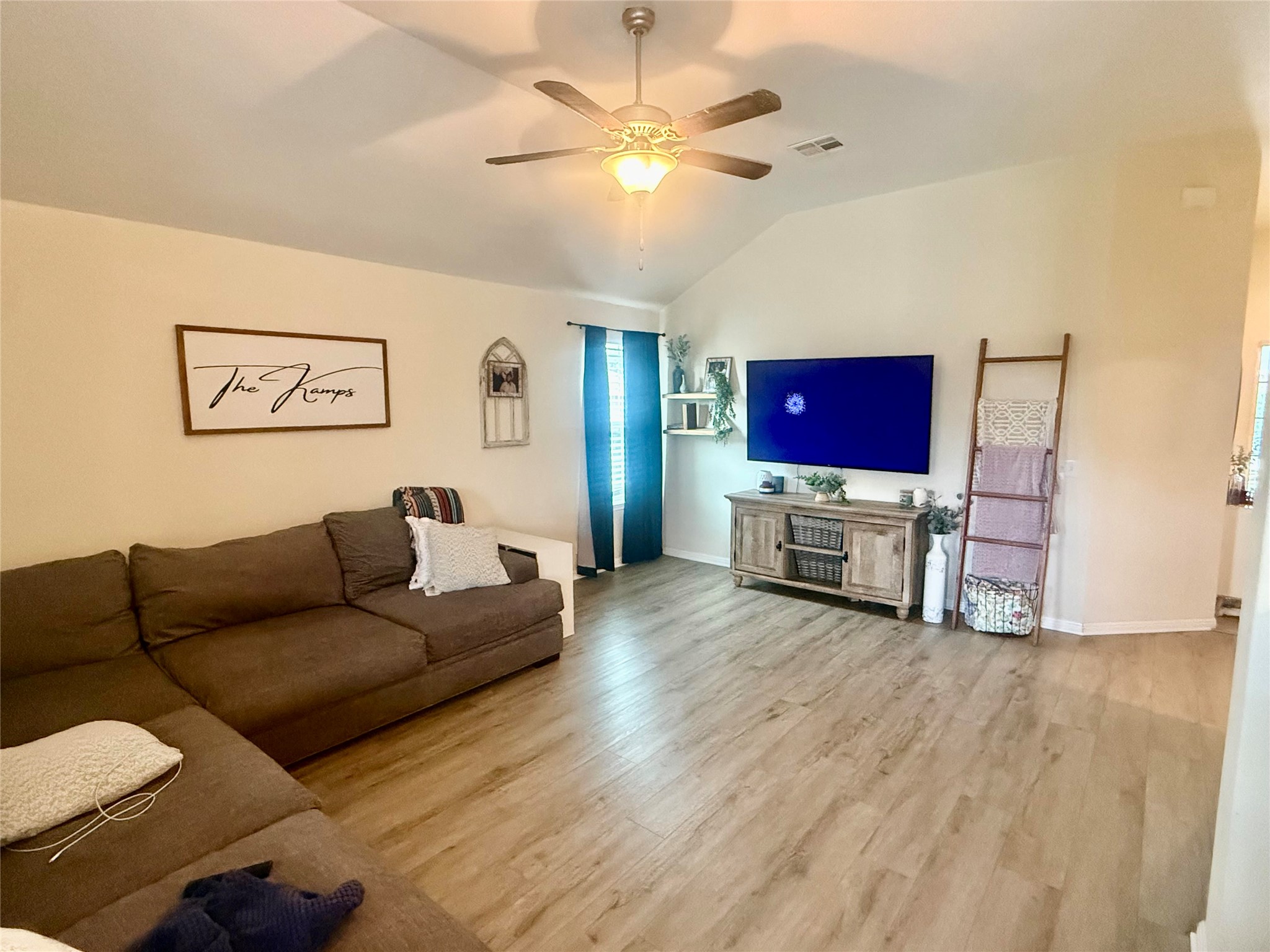107 Jim Dandy Drive Elgin, TX 78621 - Photo 8 of 15 Generous living area featuring vaulted ceilings and resilient vinyl plank flooring, ideal for everyday comfort.