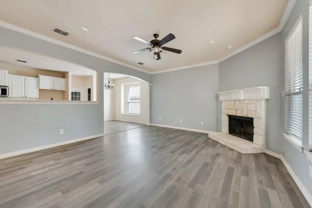 an empty room with windows and a fireplace