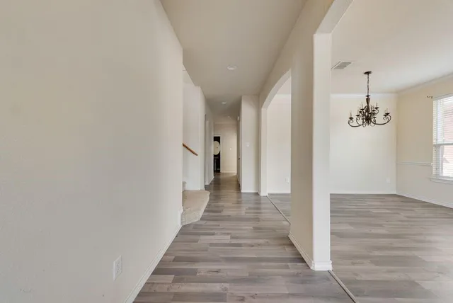 a view of a hallway with wooden floor and staircase
