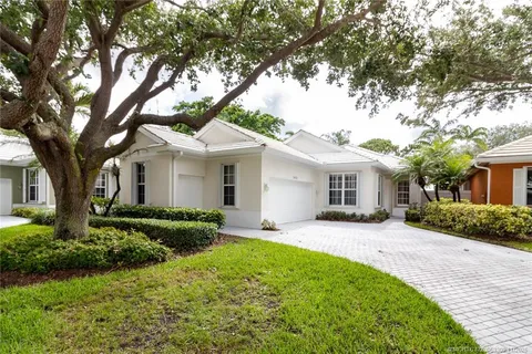 a front view of a house with a garden and yard