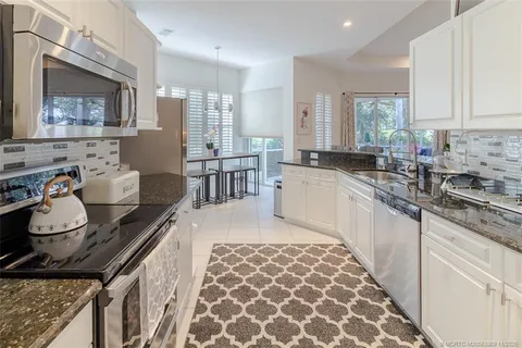 a kitchen with stainless steel appliances granite countertop a sink stove and cabinets