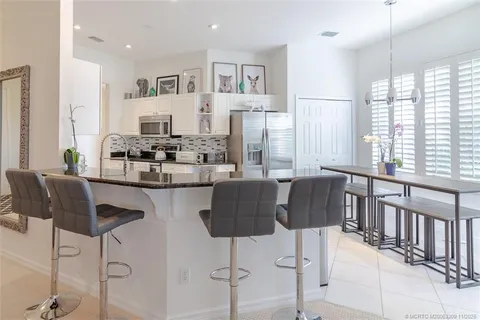 a kitchen with stainless steel appliances kitchen island granite countertop a table and chairs