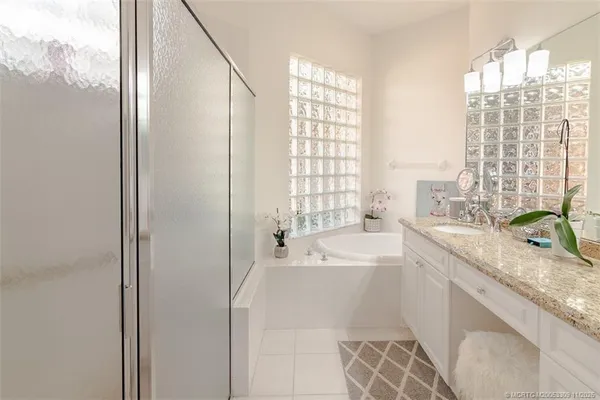 a bathroom with a granite countertop sink a bathtub and shower