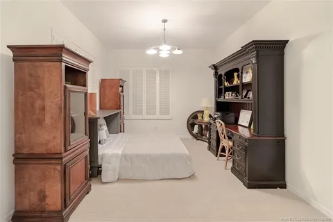 a bedroom with bed and a chandelier