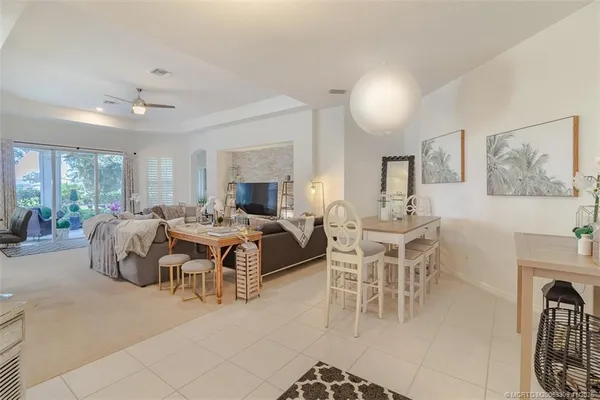a living room with furniture a large window and a chandelier