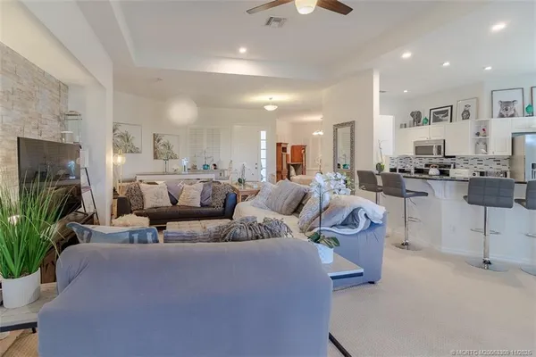 a large living room with stainless steel appliances kitchen island granite countertop furniture and a view of kitchen