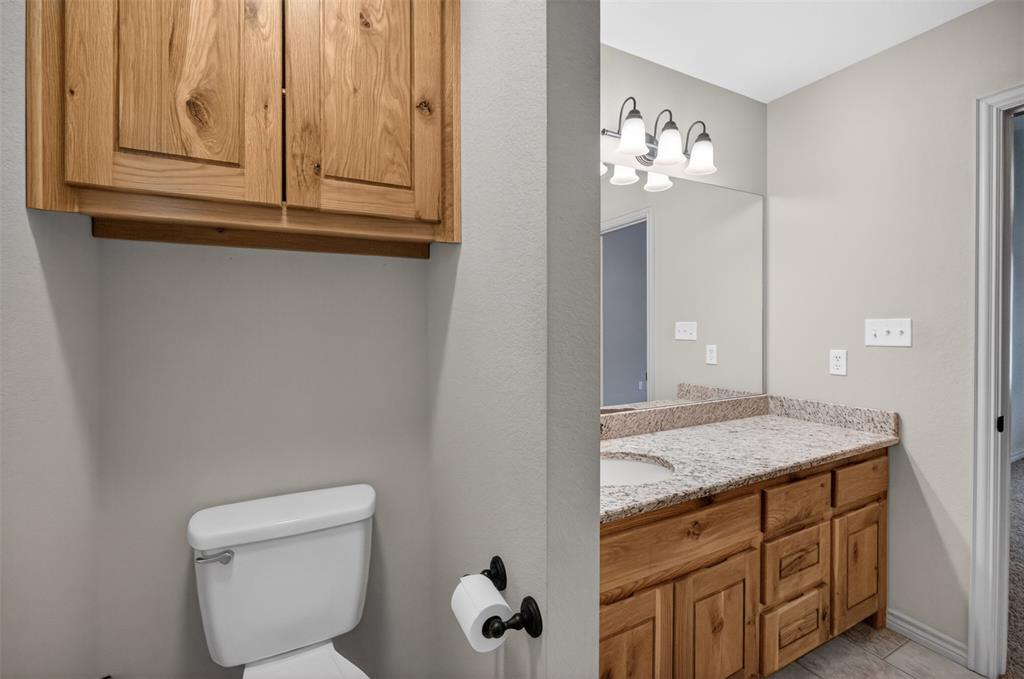 505 East 5th Street Springtown, TX 76082 - Photo 20 of 39 a bathroom with a granite countertop sink and a mirror