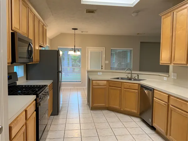 a kitchen with stainless steel appliances granite countertop a refrigerator stove top oven and sink