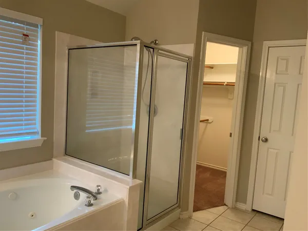 a bathroom with a tub a sink and mirrors
