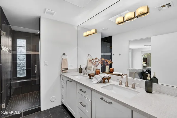 a bathroom with double vanity sinks a vanity and a mirror