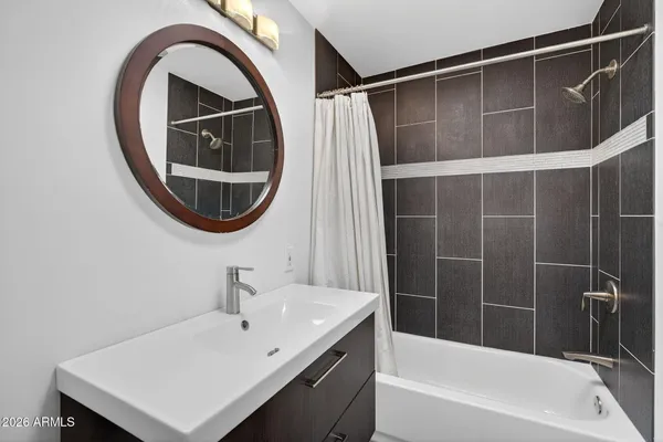 a bathroom with a sink a bathtub and a mirror