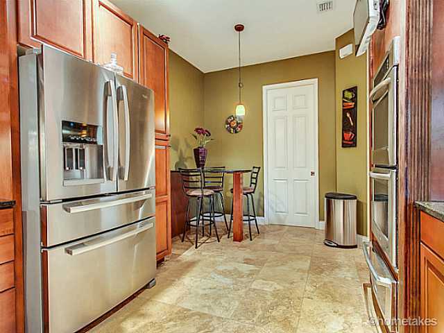 358 Southwest Walking Path Stuart, FL 34997 - Photo 3 of 22 a kitchen with stainless steel appliances granite countertop a refrigerator and a sink