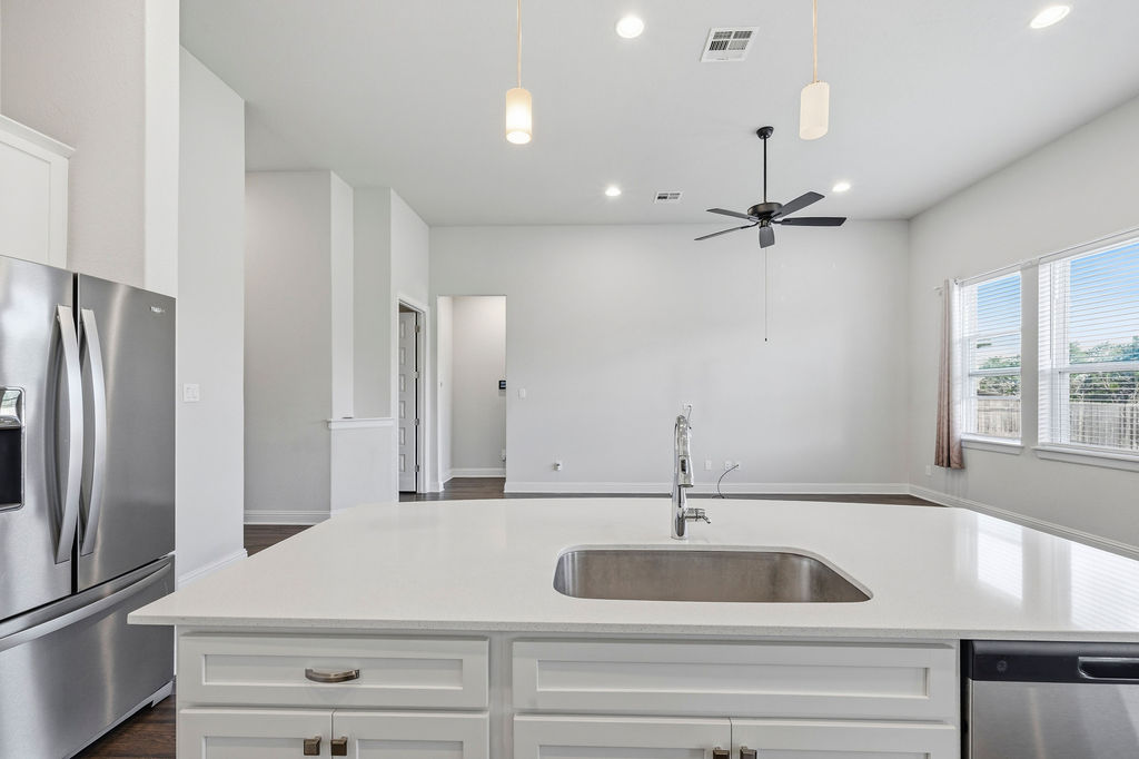 2032 Base Burner Path Leander, TX 78641 - Photo 27 of 34 Kitchen island featuring a stainless steel sink, contemporary faucet, and white cabinetry with brushed nickel hardware