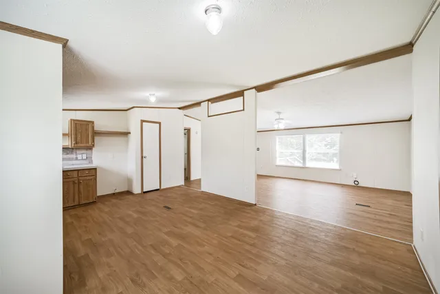 a view of empty room with wooden floor