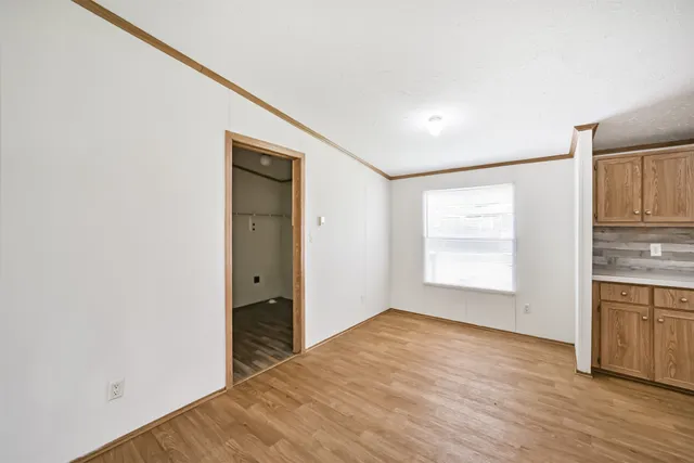 a view of a kitchen with wooden floor and a window