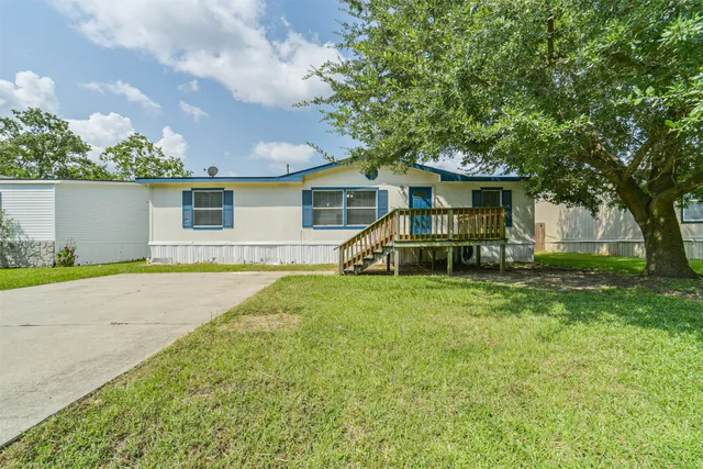 a view of a house with backyard and a tree