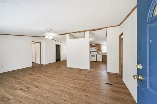a view of a big room with wooden floor and windows